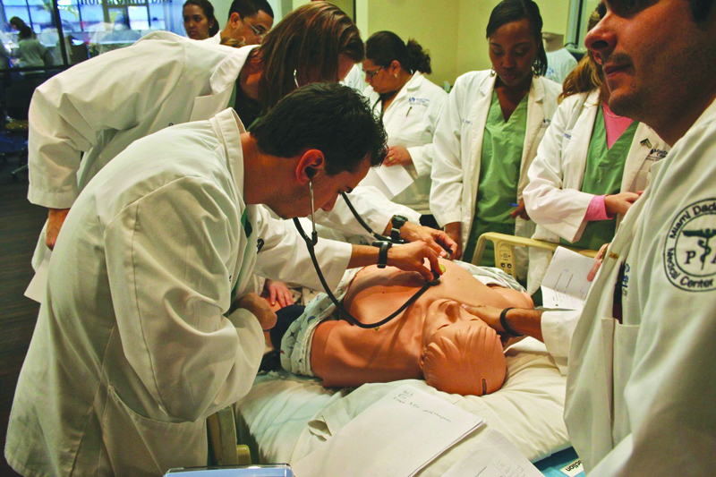 Nursing students practicing on patient dummy.