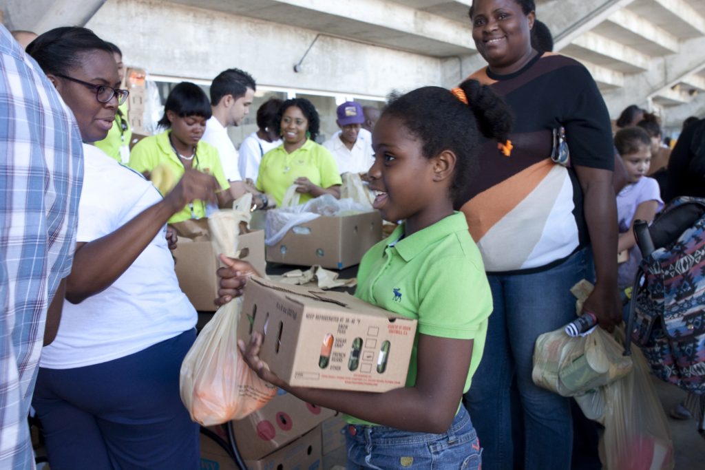 A young girl receiving food from FarmShare.