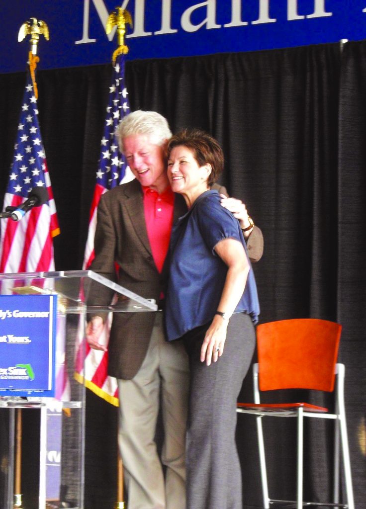 Bill Clinton and Alex Sink on stage.