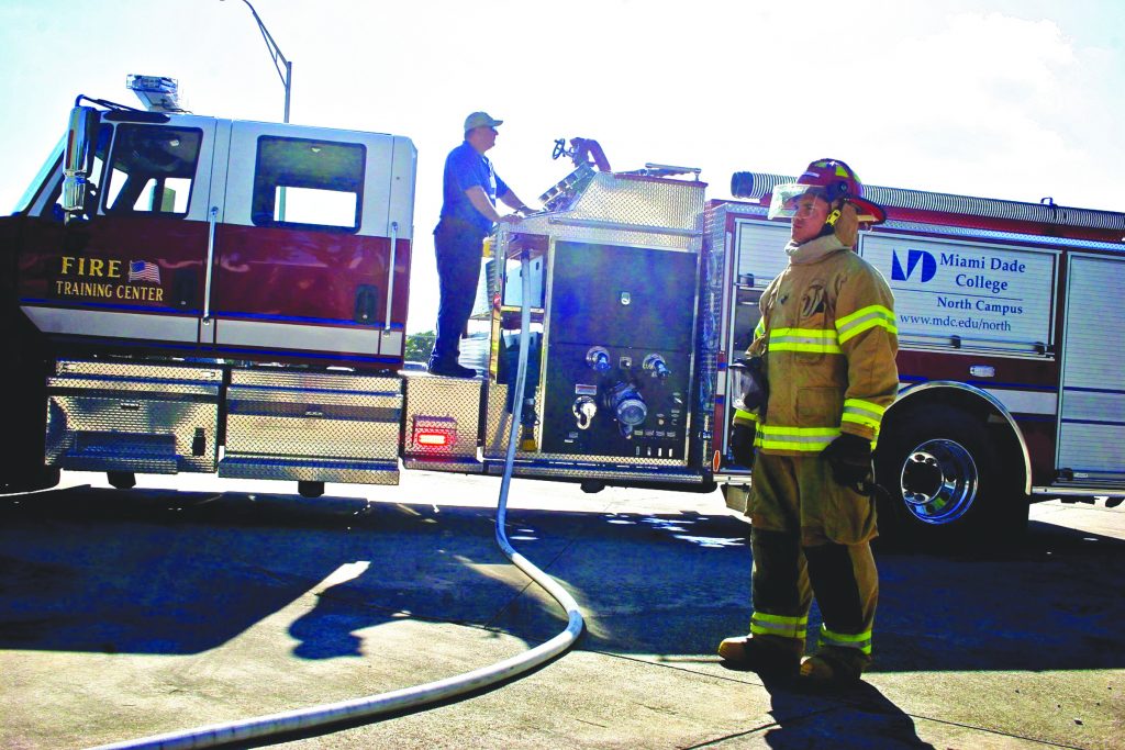 Captain Chris Cox inspecting the new truck while a student looks on.