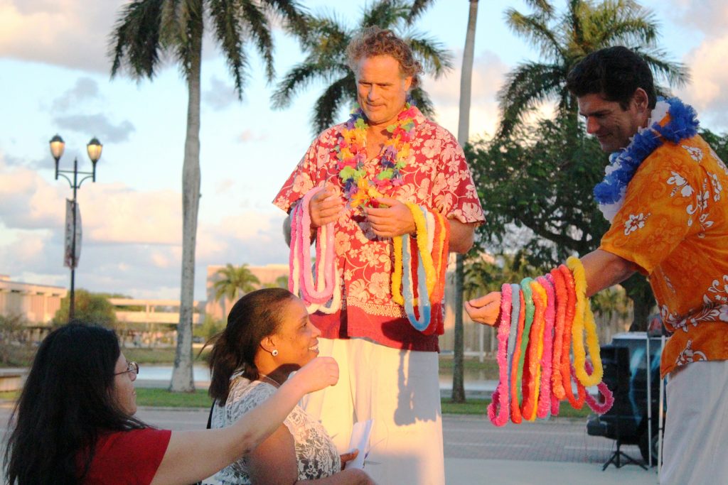Students receiving floral necklaces.