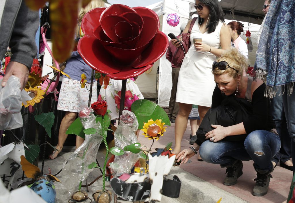A woman looking at hand made yard art.