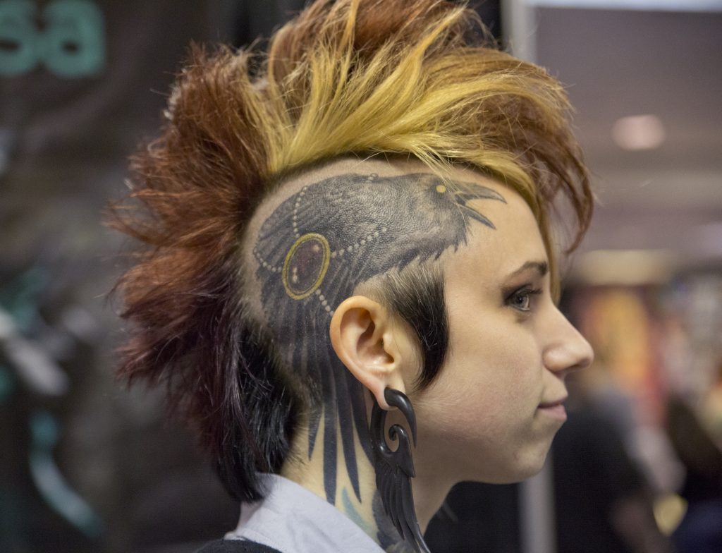 A young woman showing off her tattoo at TattooLapalooza.