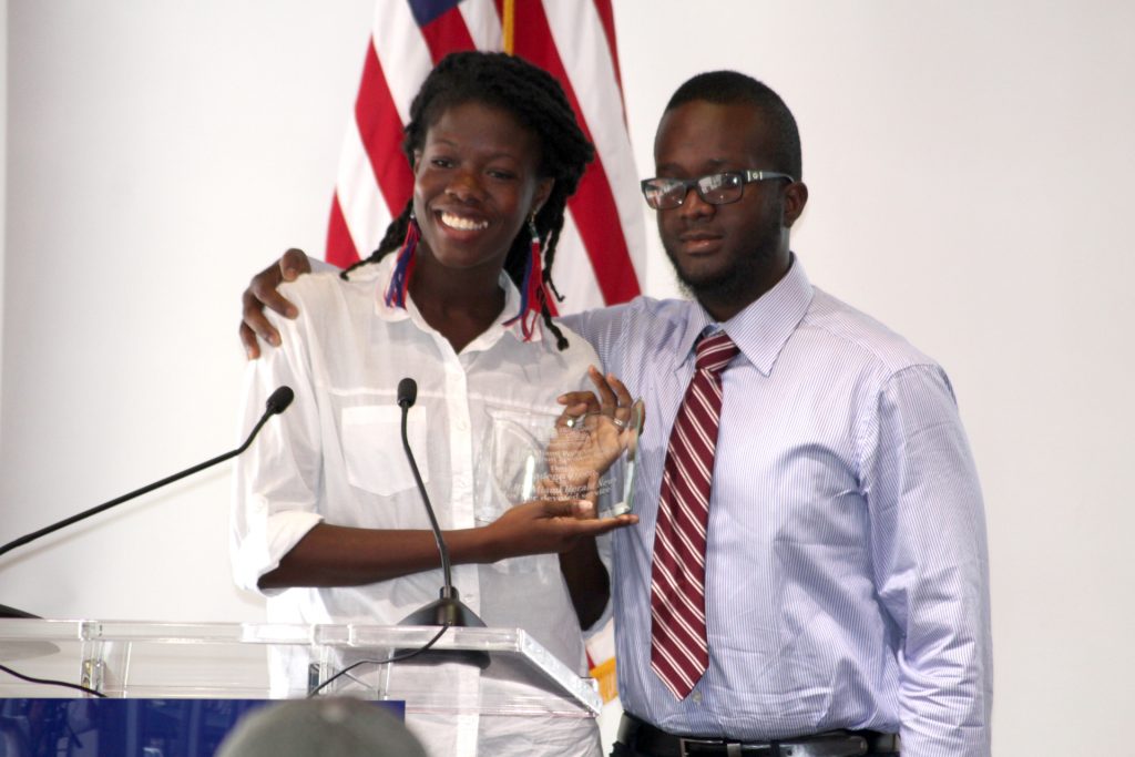 Reporter Nadege Green receiving a token from a Reporter student.