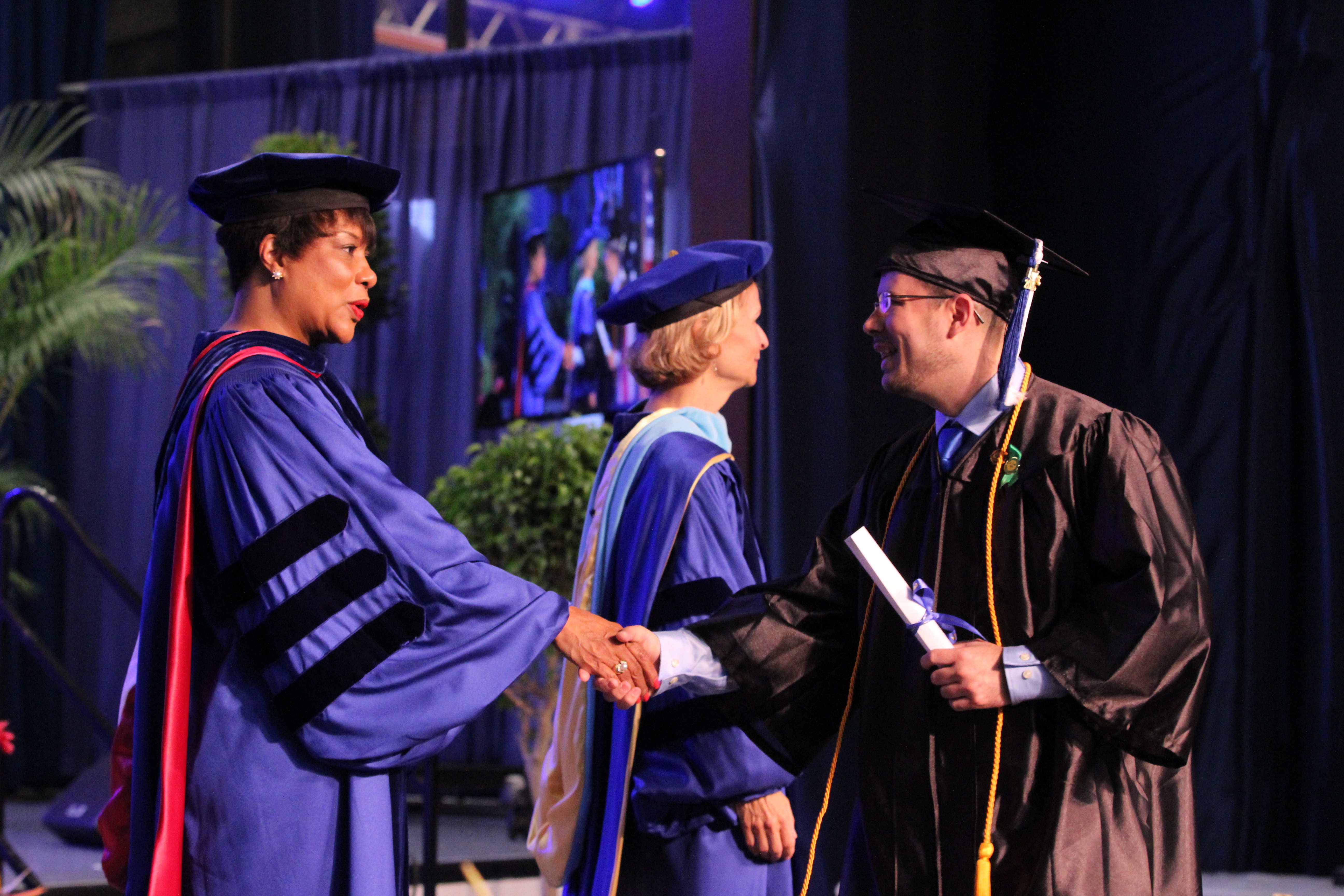 Student receiving his degree on stage at graduation.