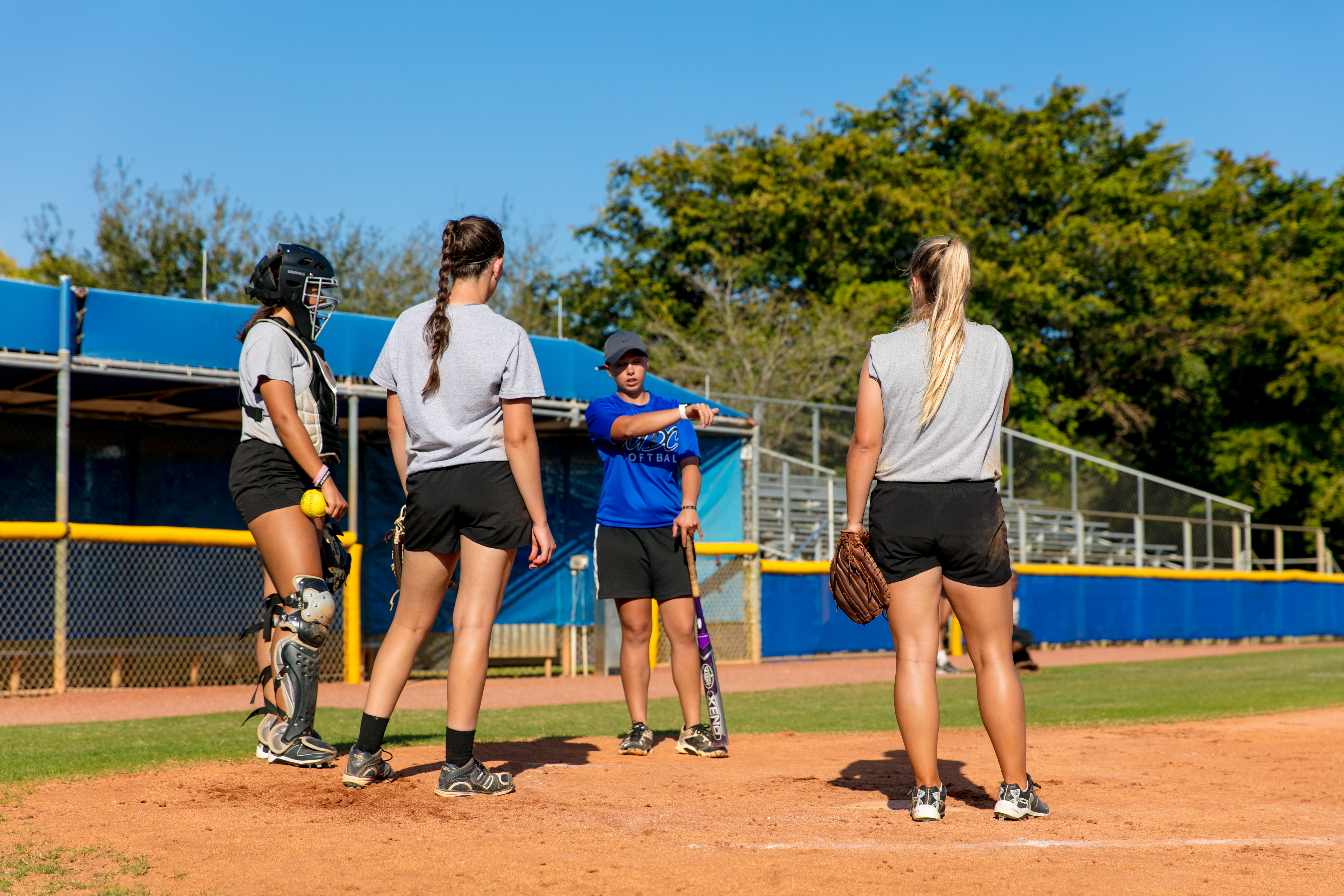 Lady Sharks softball team players on the field practicing.
