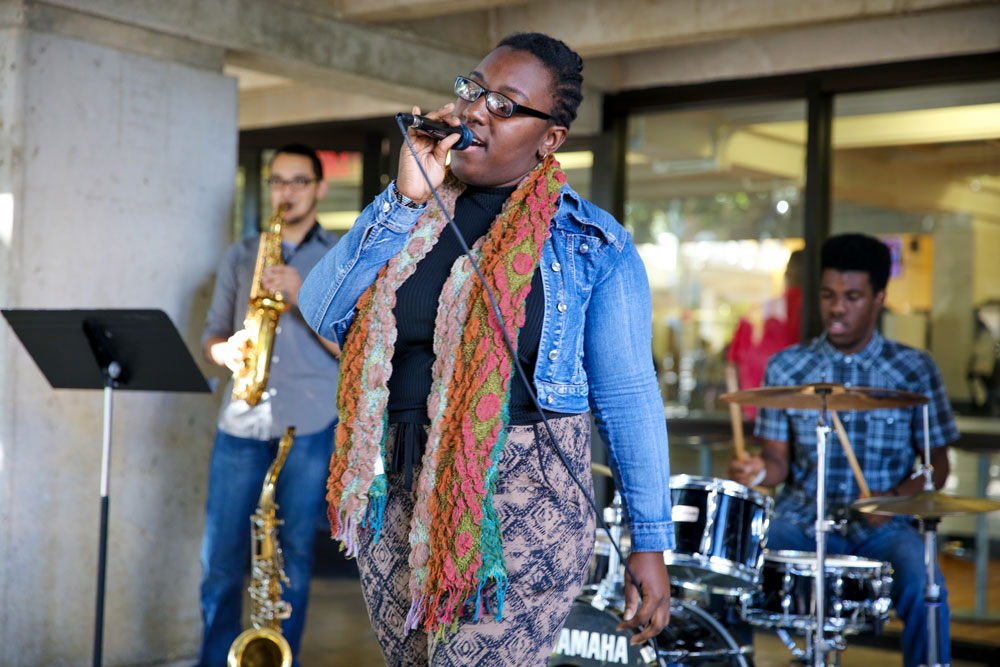 Jenna Gunter of Vocal Fusion performing along with the band in front of Koffehouse in Kendall Campus.