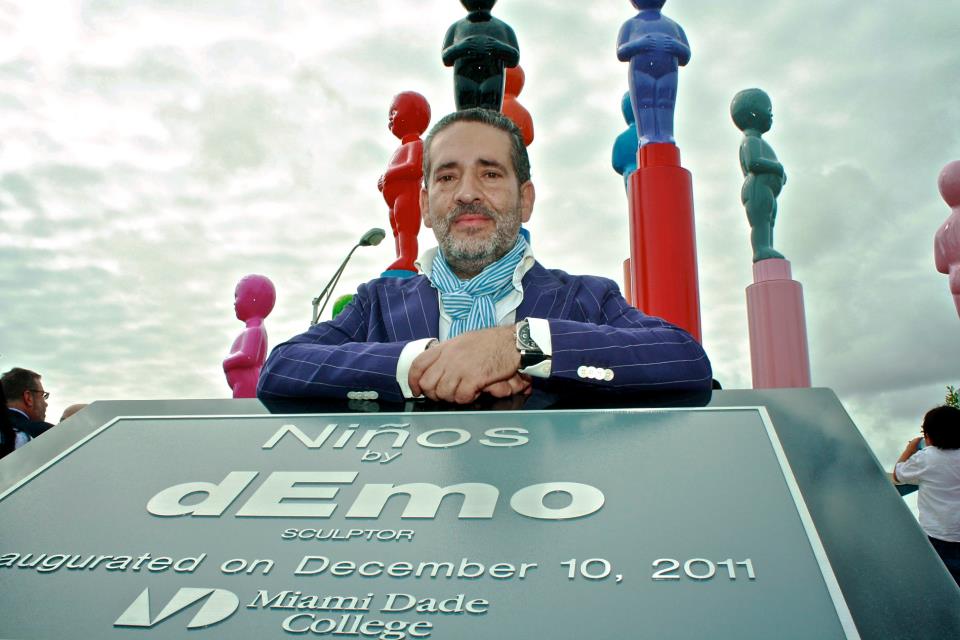 Artist dEmo posing with his sculptures.