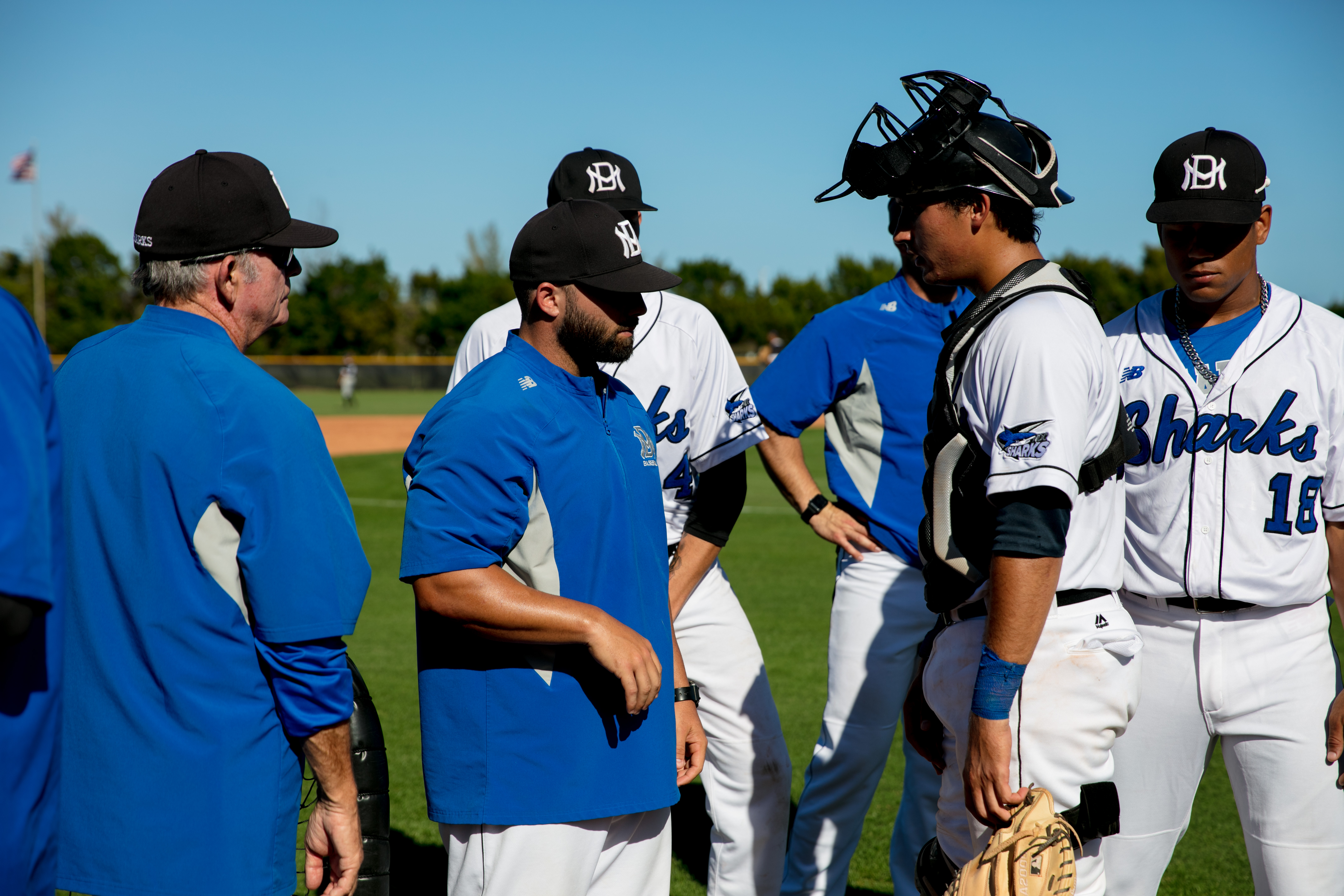 Assistant coach talking to catcher.