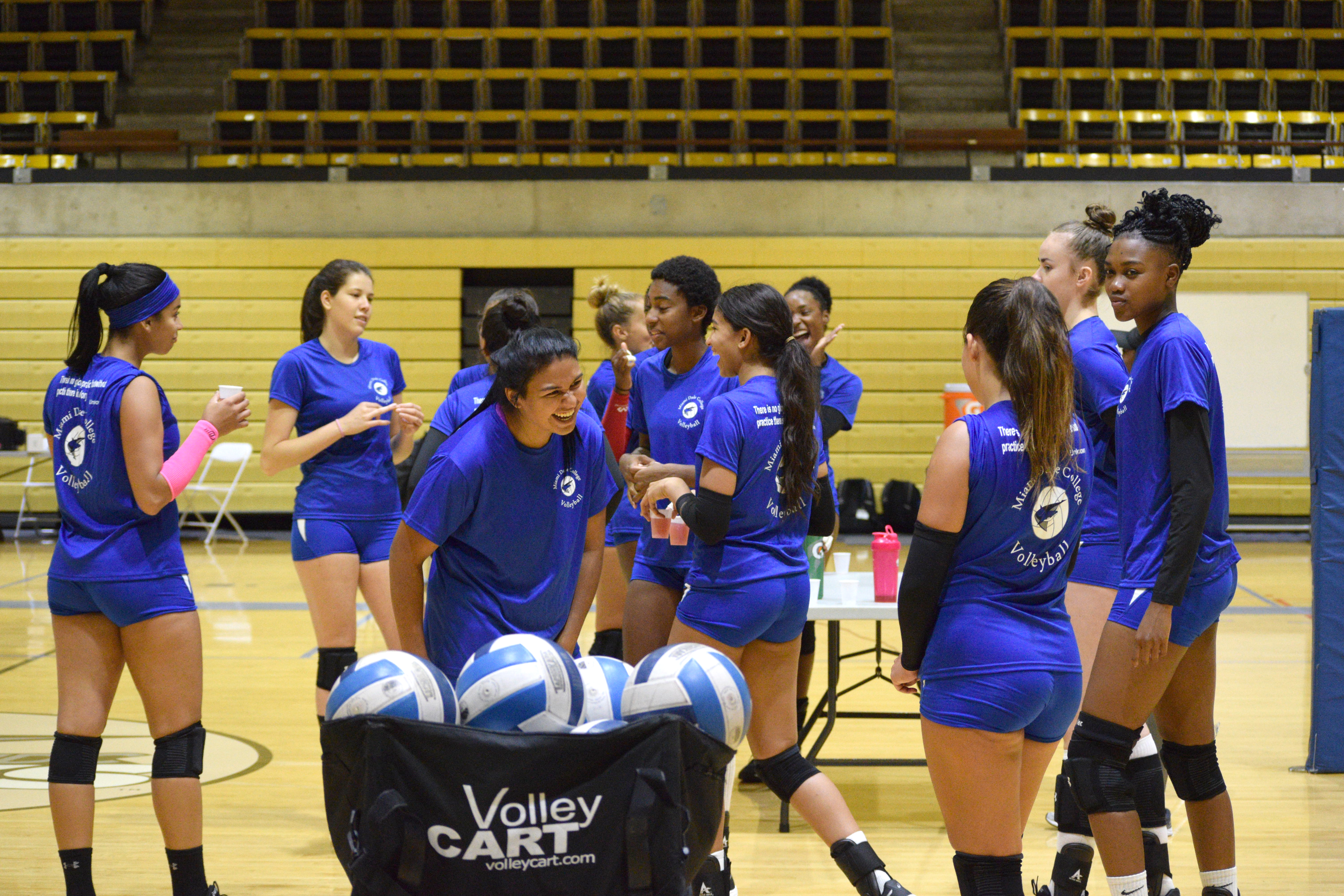 The Lady Sharks volleyball team interacting with each other during practice.