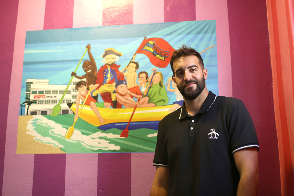 Mike Ryan Ruiz standing next to an artwork based on the show.