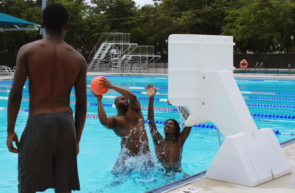 Students playing basketball in the pool.