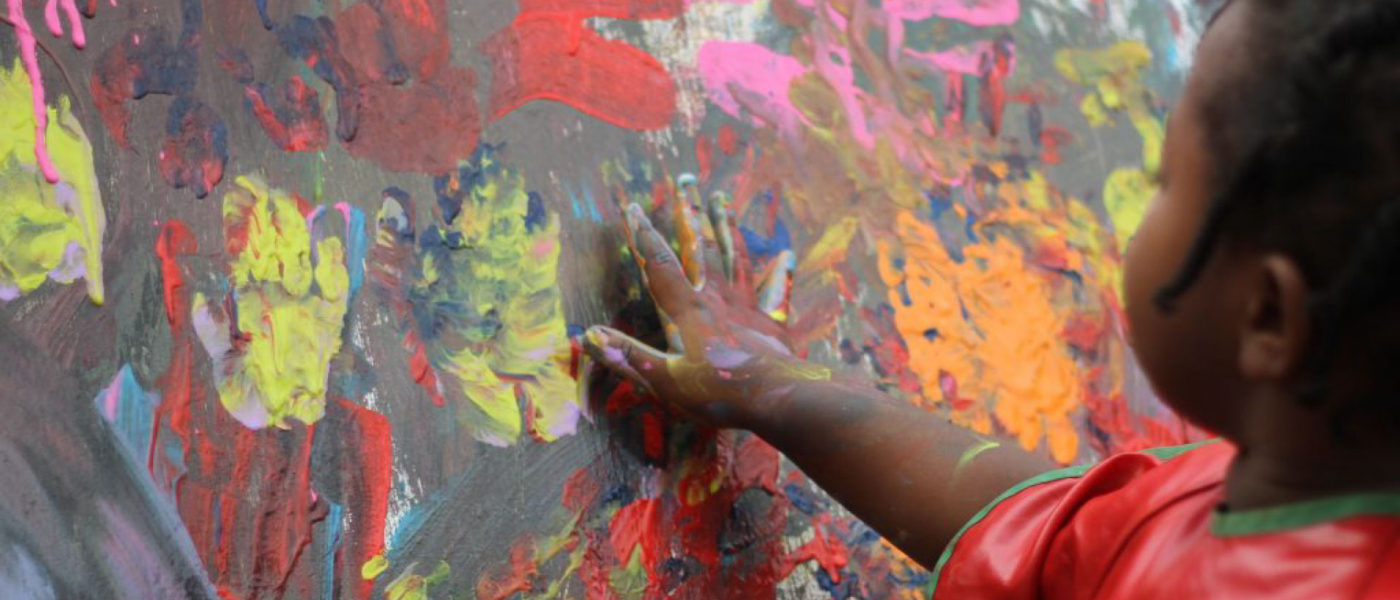 A little girl finger painting.
