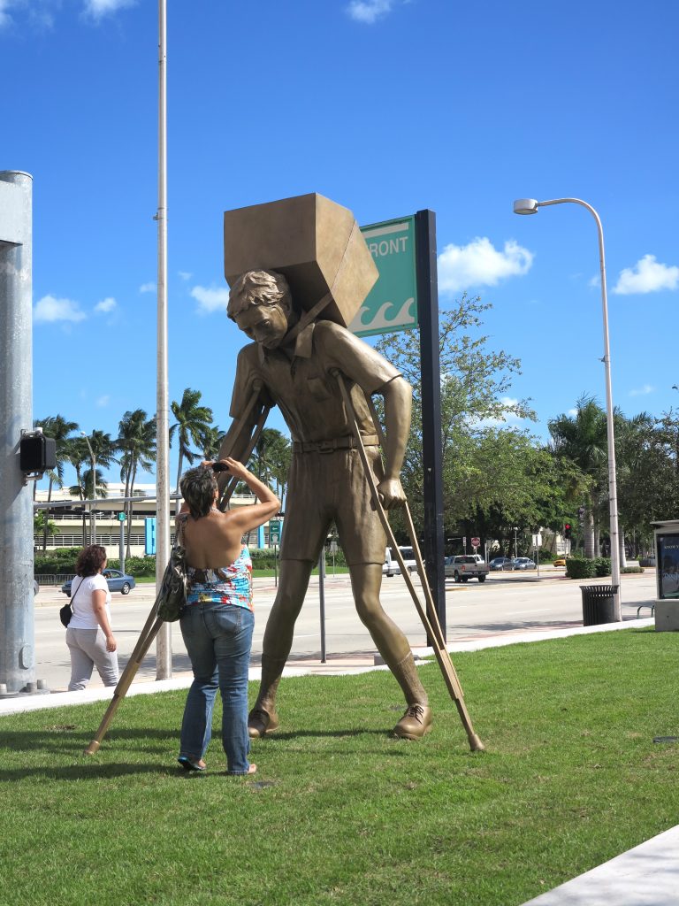 A woman taking a picture of the sculpture.