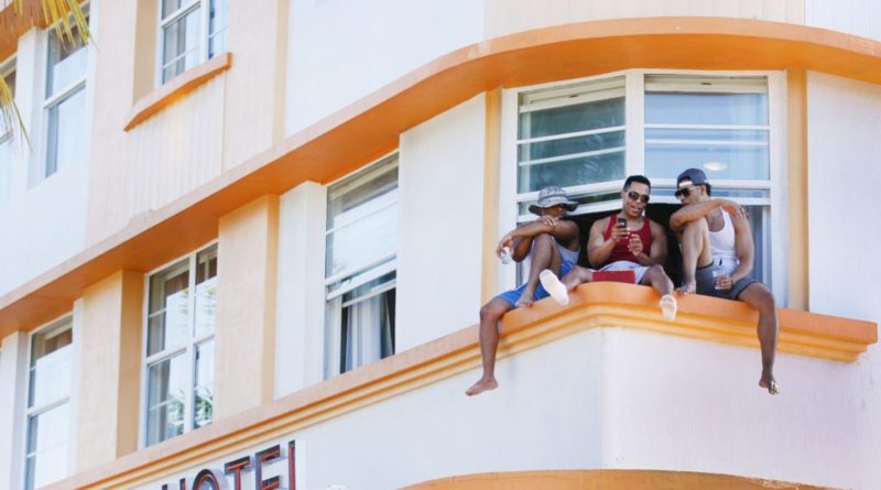 Three men sitting at their hotel window.