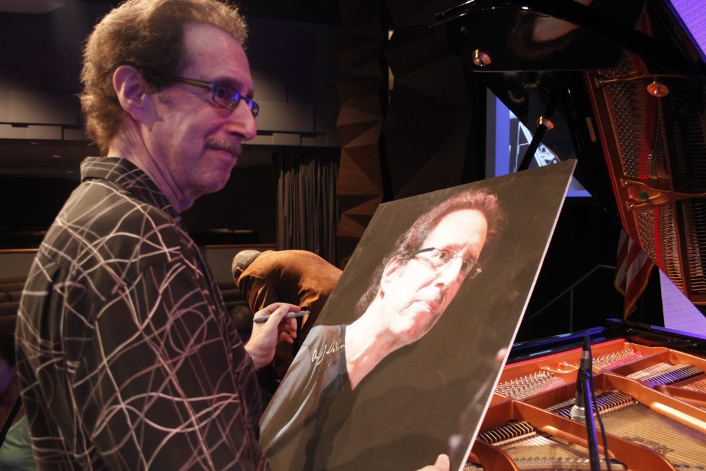 Jazz musician Andy LaVerne signing posters.