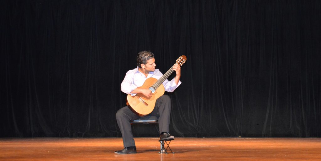MDC student playing his guitar on stage.