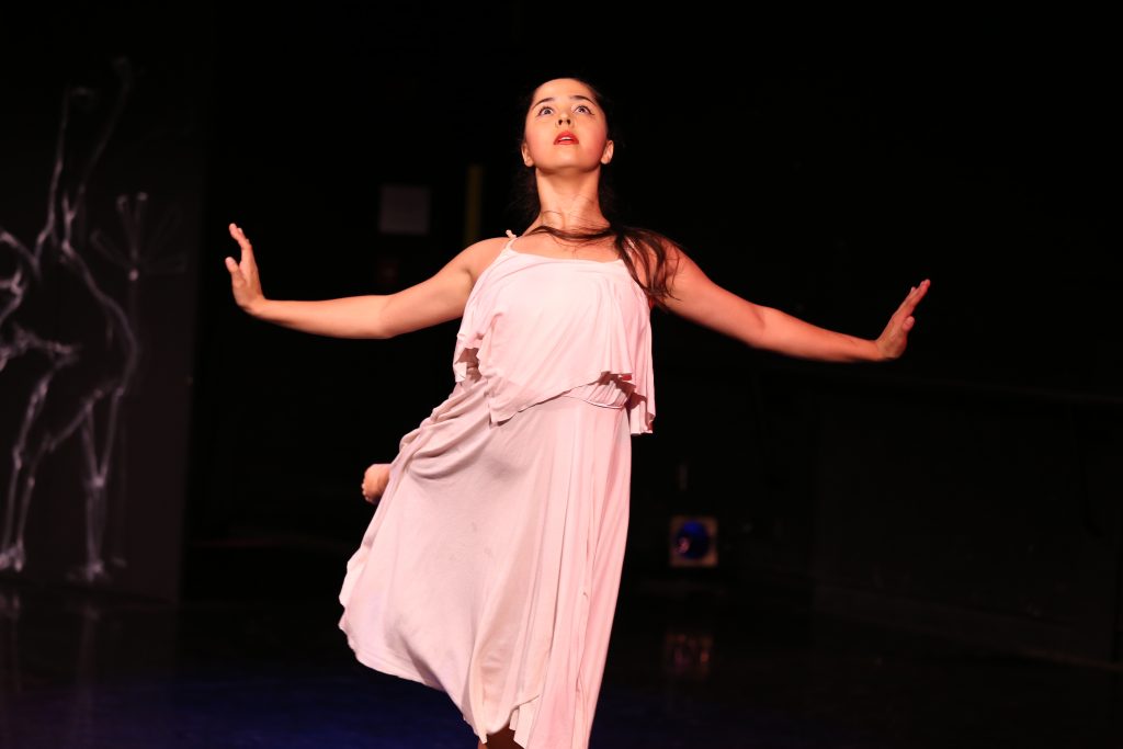Student performing a dance on stage.