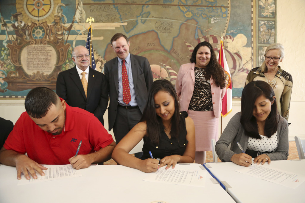 Photo of undocumented students signing their scholarships.