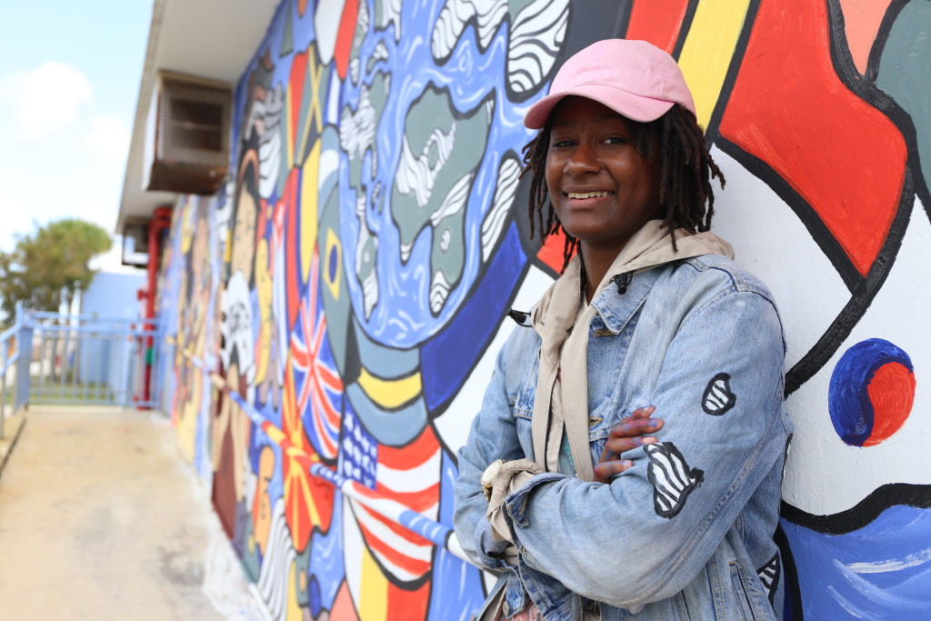 Sheleah "Sunchild" Parks standing next to her completed mural at North Dade Middle School.