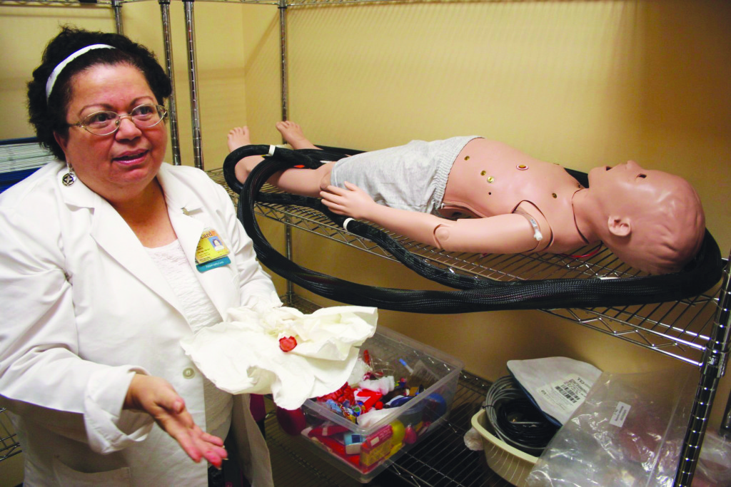 Professor Yamina Alvarez sitting next to a dummy.