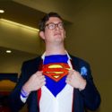 A cosplayer dressed as Clark Kent/Superman.