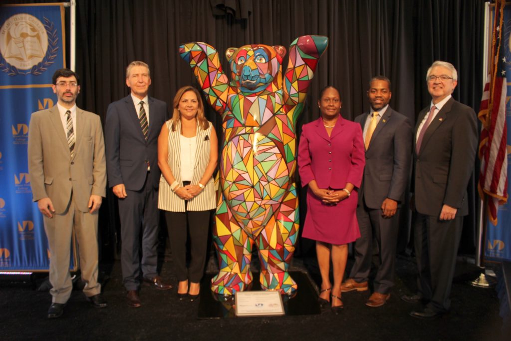 People posing next to Buddy Bear.