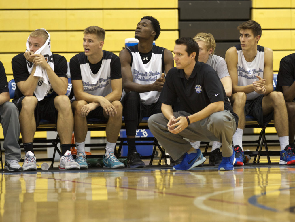 Stephen Cowherd and the team sitting on the side during a game.