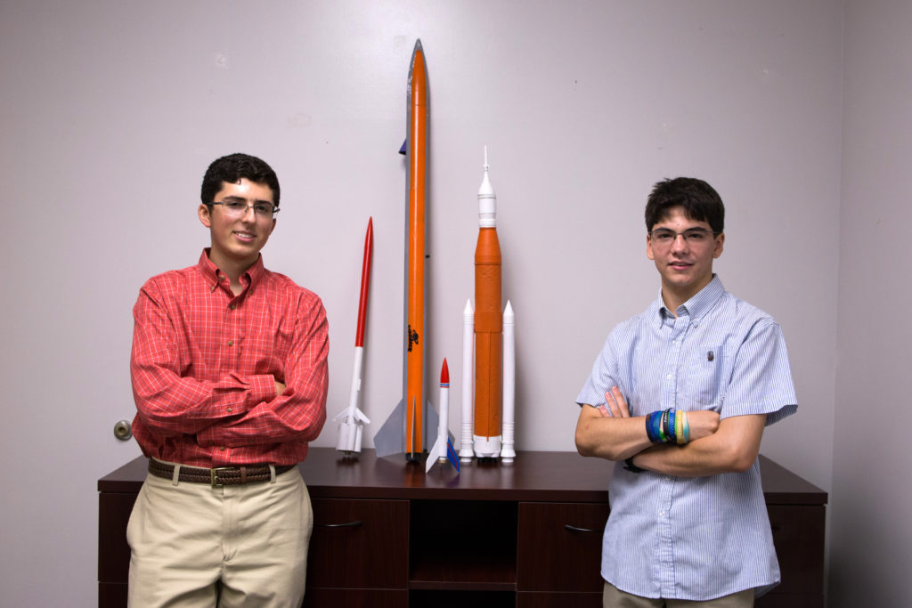 Abisleiman and Ruiz posing with model rockets. ready for space launch.