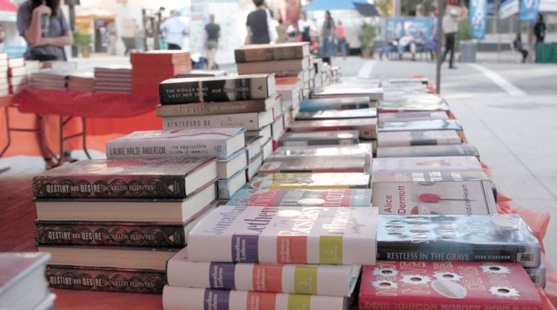 Piles of books on a table at the Miami Book Fair.