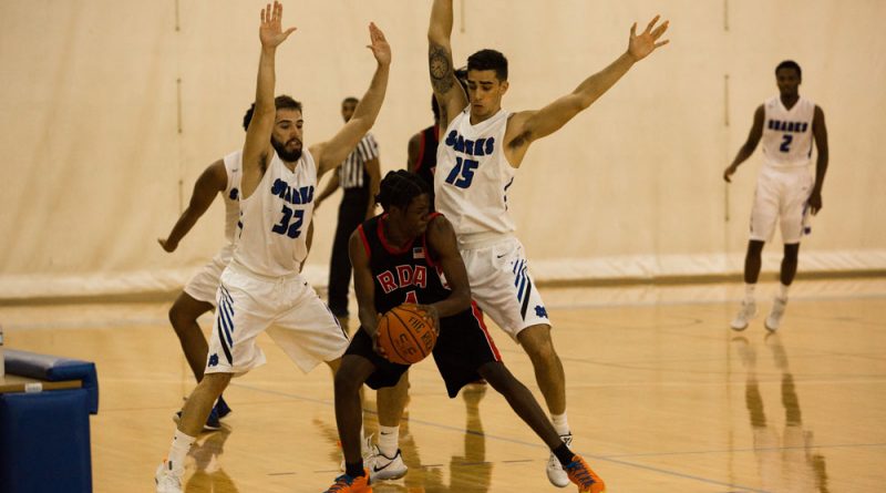MDC Sharks basketball players trapping an opposing player.