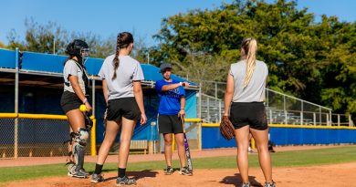 Lady Sharks softball team players on the field practicing.