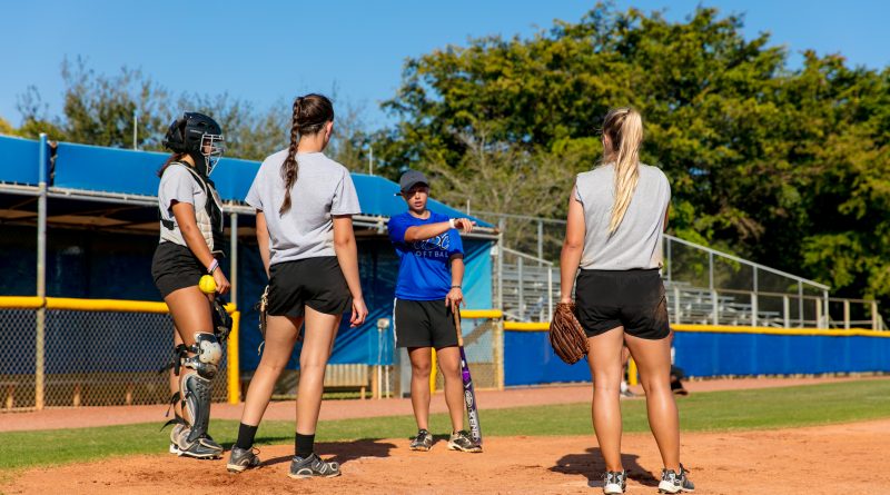 Lady Sharks softball team players on the field practicing.