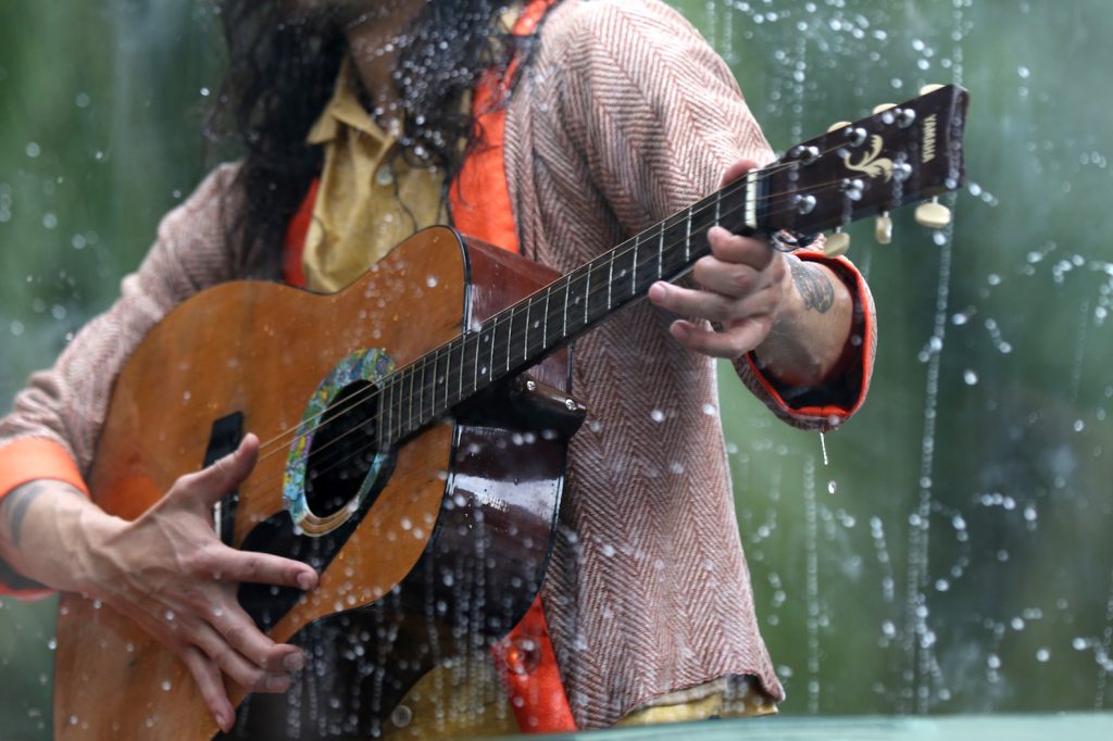 Musician Benjamin Kamino playing his guitar in a tank as part of the art installment Holoscenes.