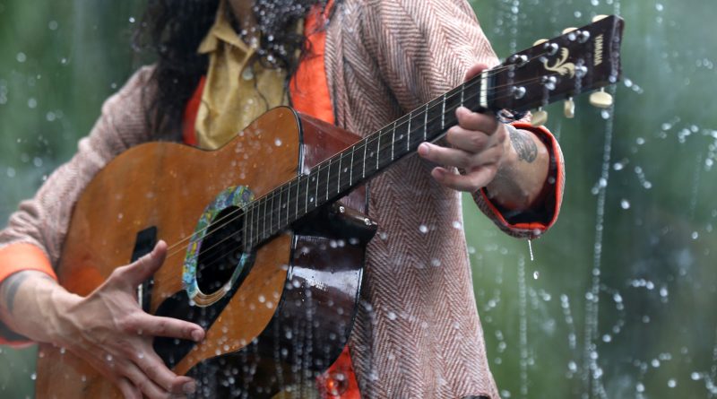 Musician Benjamin Kamino playing his guitar in a tank as part of the art installment Holoscenes.