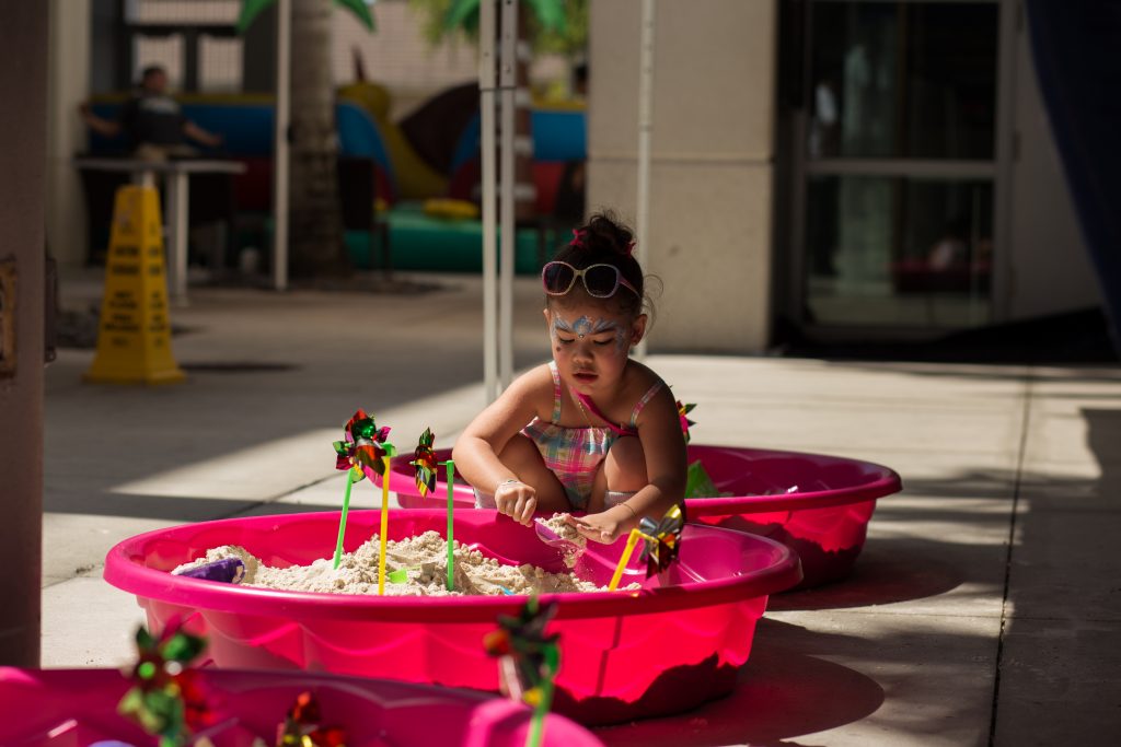 Three-year-old child plays with sand