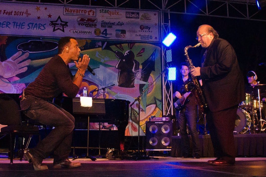 Jon Secada and Ed Calle performing on stage.