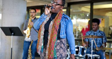 Jenna Gunter of Vocal Fusion performing along with the band in front of Koffehouse in Kendall Campus.