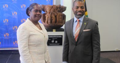North Campus President Malou C. Harrison and Consulate General of Jamaica Franz Hall posing in front of the sculpture.