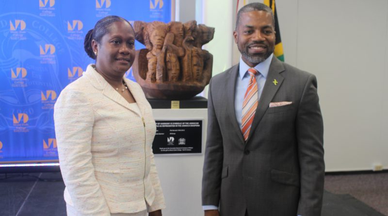 North Campus President Malou C. Harrison and Consulate General of Jamaica Franz Hall posing in front of the sculpture.