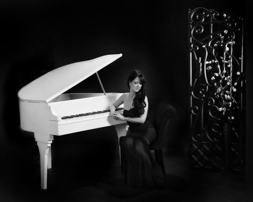 Ana Rodriguez with her piano in a glamour shot.