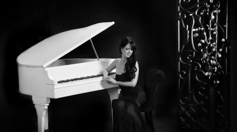 Ana Rodriguez with her piano in a glamour shot.