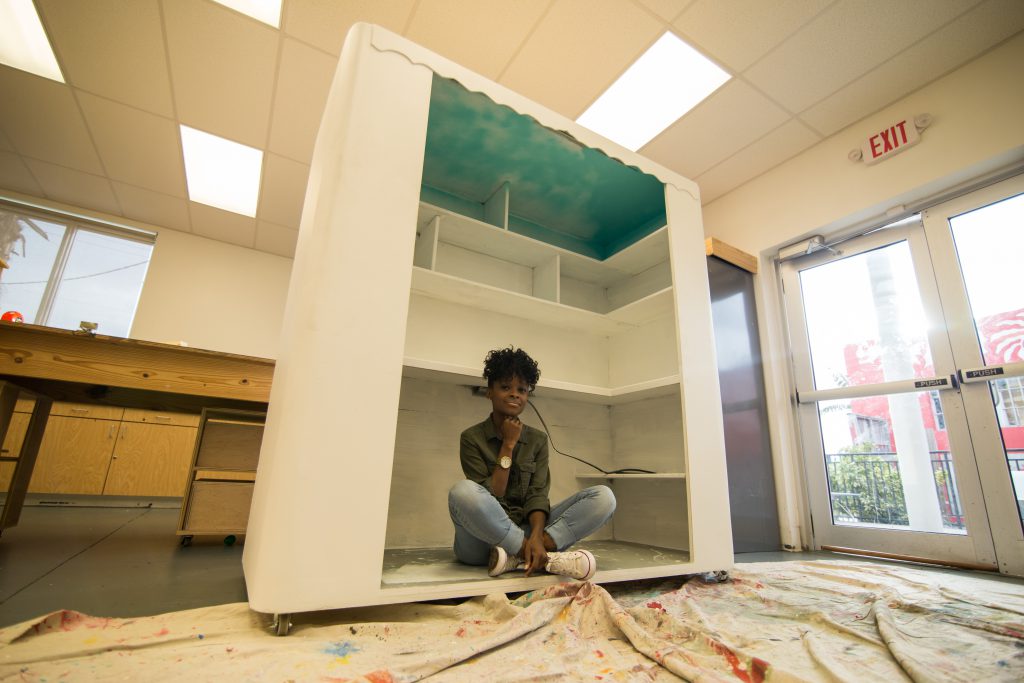 Suze Guillaume sitting in her mobile pop-up book shop.