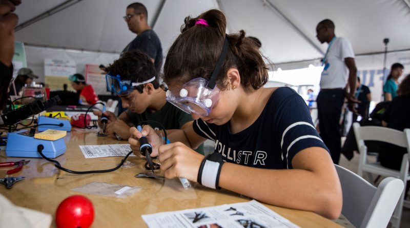 Young student learning how to solder.