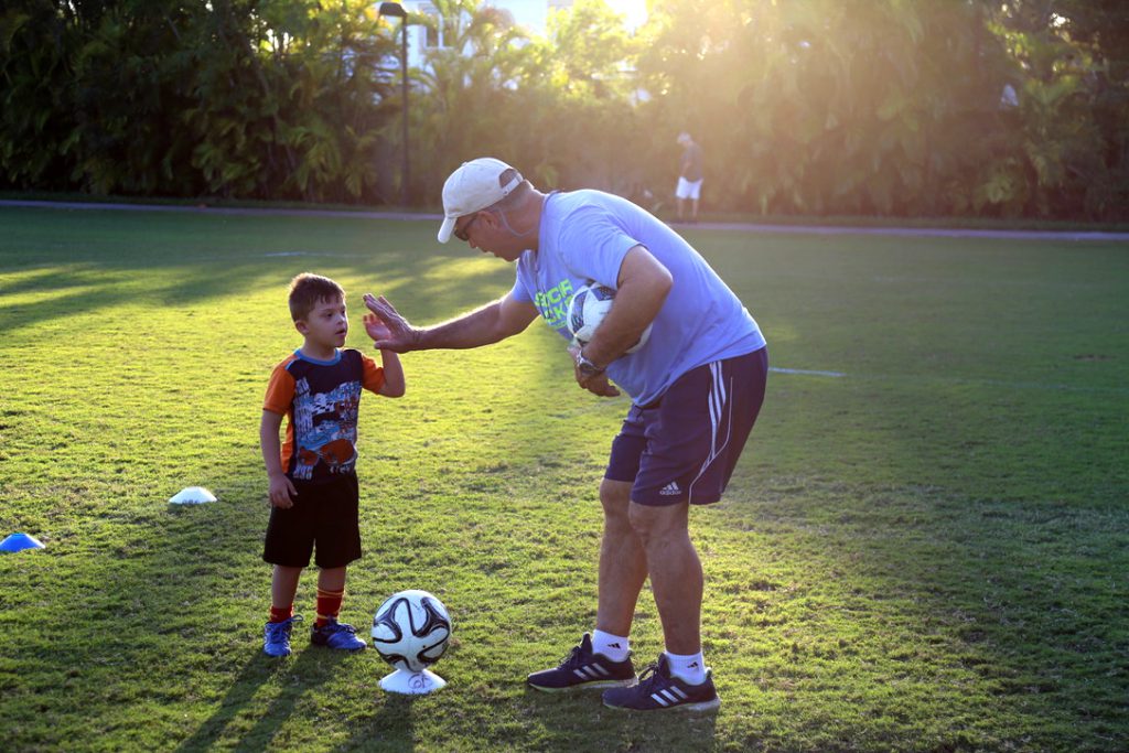 Antonio "Motor" Paz high fives a child.