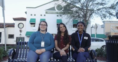 Students Franchesca Carr, Lydia Hussain and Samarah Martin sitting in front of the Historic Homestead Town Hall Museum.