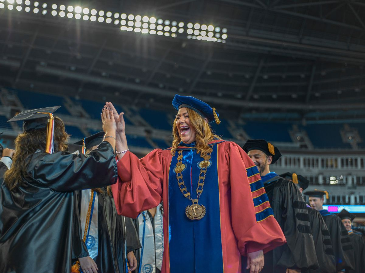 High-Five: Miami Dade College President Madeline Pumariega congratulates a graduate at Commencement 2026. LUCAS DUARTE/THE REPORTER