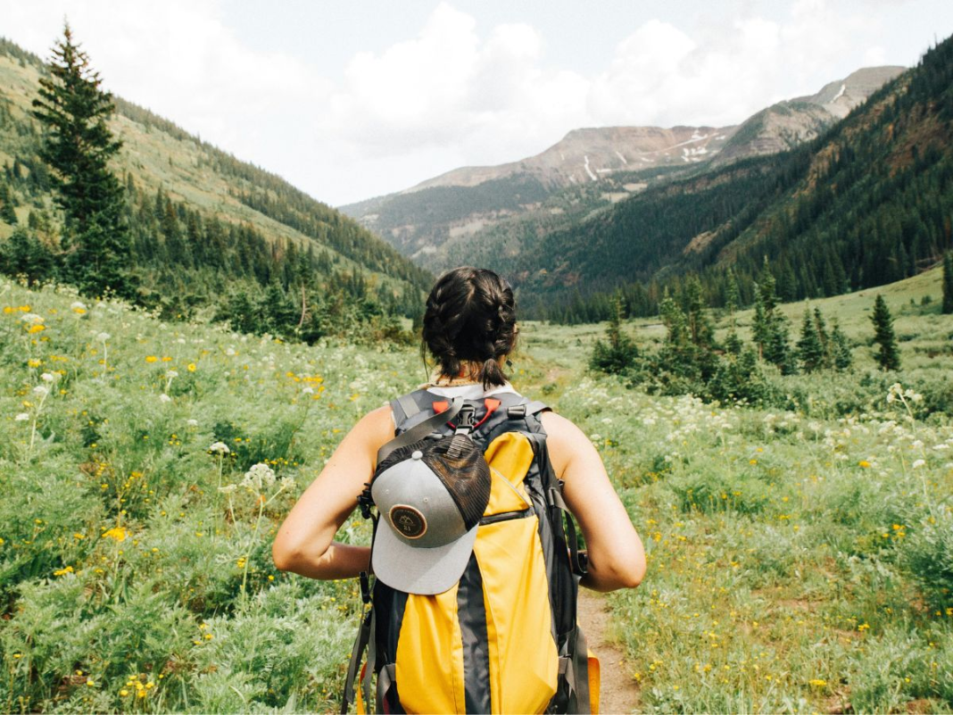 A young lady hiking with a backpack.